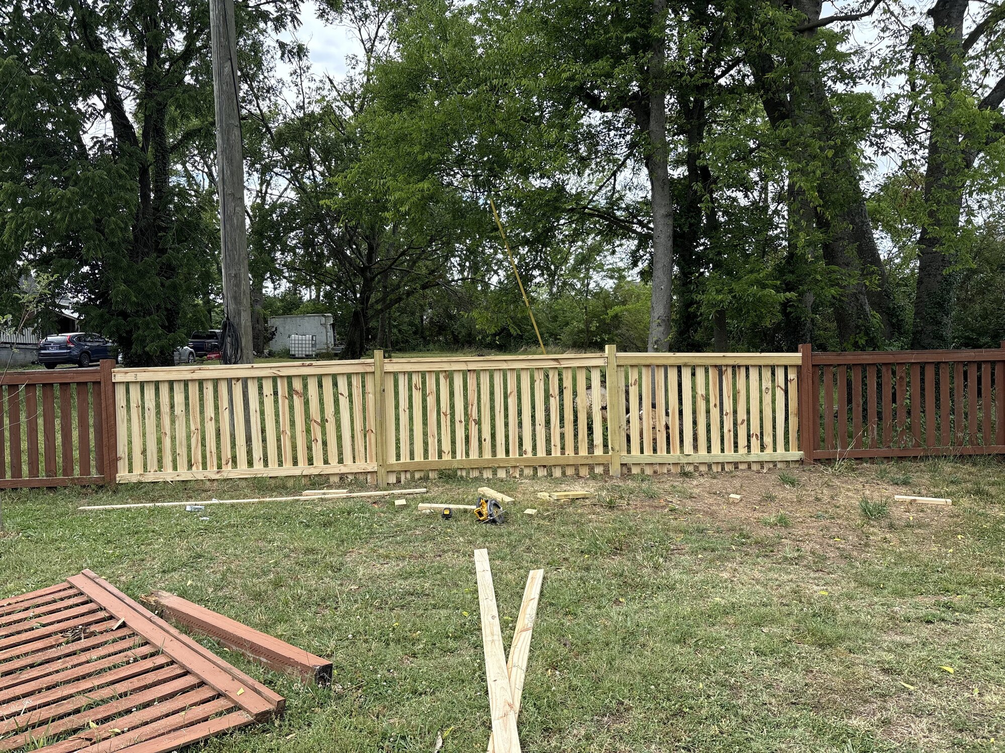 Neat backyard with trimmed grass along a wood fence